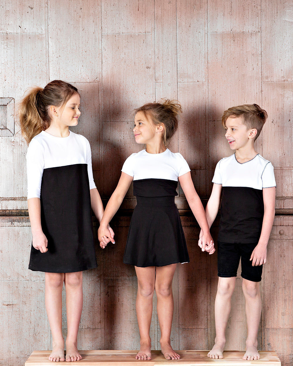 3 young children wearing matching color block, black and white clothes