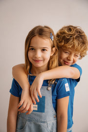 Two children hugging each other against a plain background