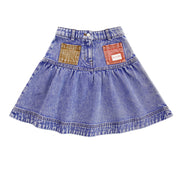 Blue denim skirt with patch details on a white background