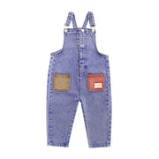 Blue denim overalls with brown patches on a white background