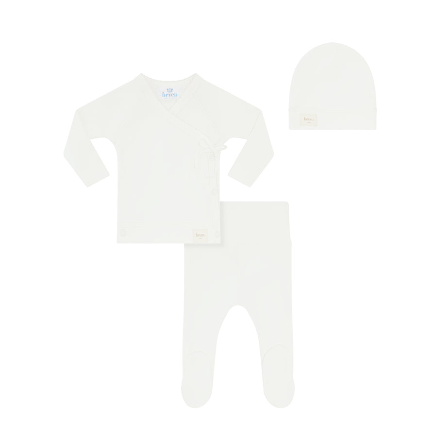 White baby outfit with long-sleeve shirt, pants, and hat on a white background