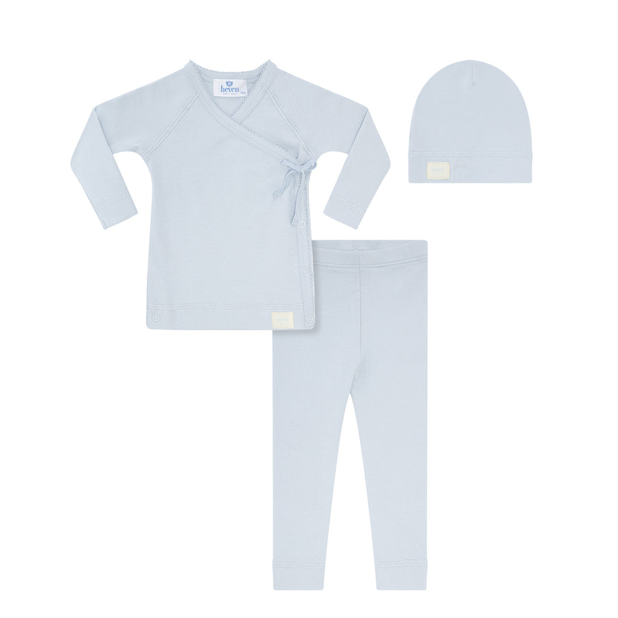 Baby clothing set with long-sleeve shirt, pants, and hat on a white background