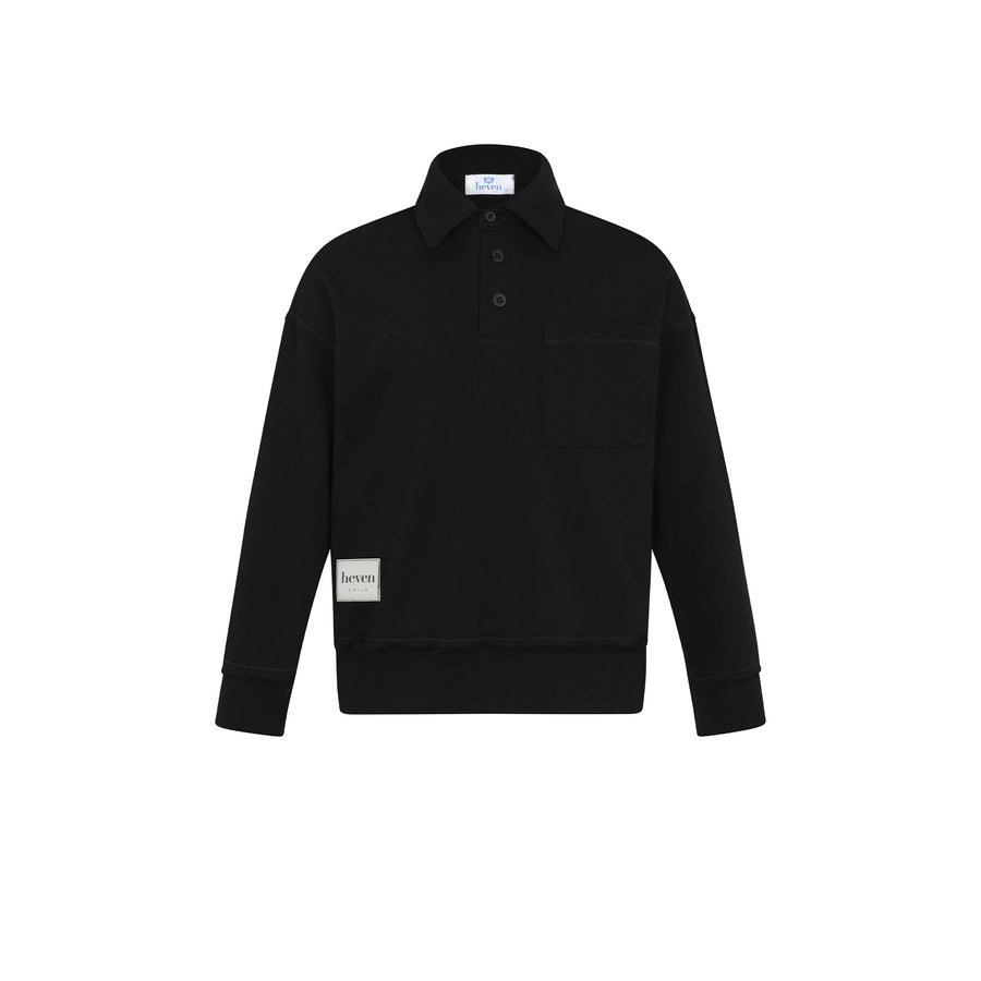 A black long-sleeve collared pullover shirt with a buttoned placket, a chest pocket, and a small beige brand patch near the lower left hem, shown on a plain white background.