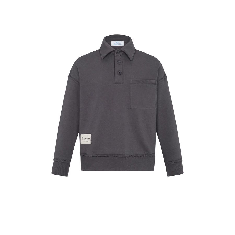 A dark gray long-sleeve polo shirt with a buttoned collar, a chest pocket, and a small beige brand patch on the lower left sleeve, shown against a plain white background.