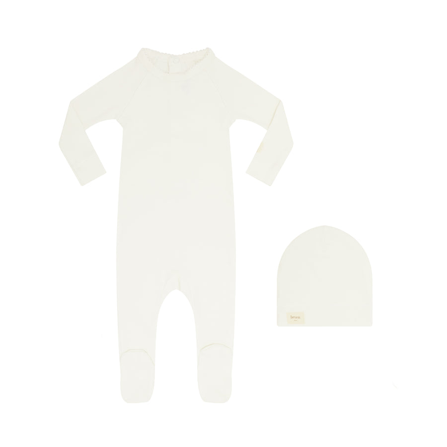 Ivory footsie with matching beanie on a white background.