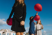 two girls wearing long sleeve T-shirts playing with ballooms