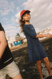 Little girls wearing the royal blue knee length cotton T-shirt dress with baseball cap and sandals