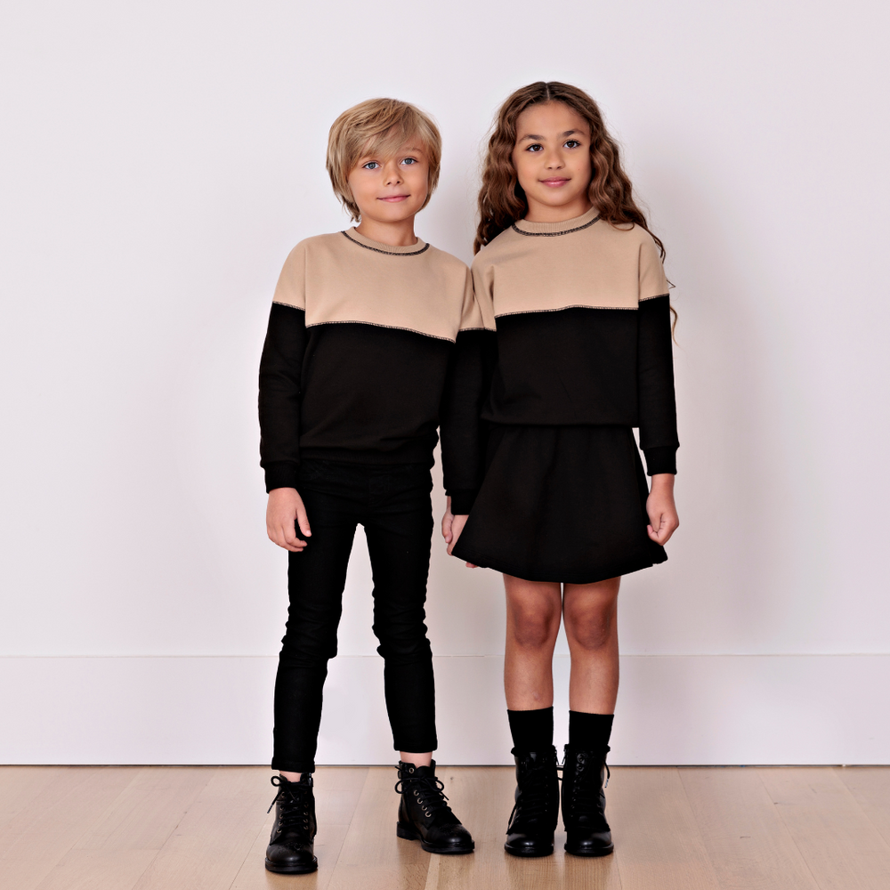 young girl and boy wearing matching tan and black color block sweatshirts